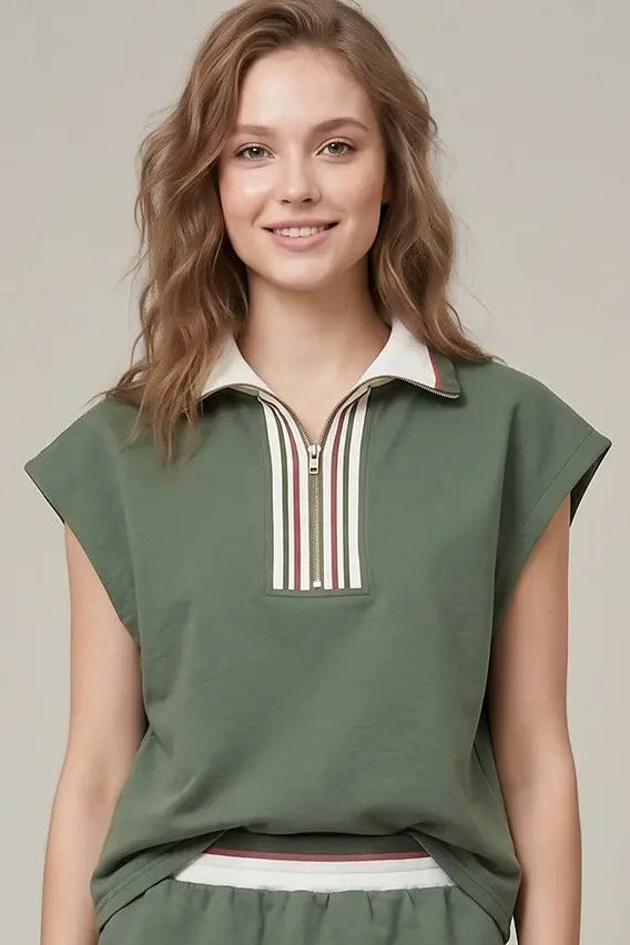 Woman wearing a green dress with a white collar against a beige background